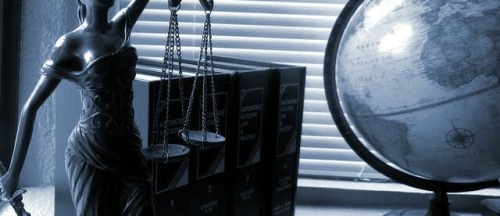 תמונת נושא של דף שירותבניית אתרים לעורכי דין המציגה פסל טיימיס, ספרי חוק וגלובוס מונחים על אדן חלון ליד תריסים סגורים